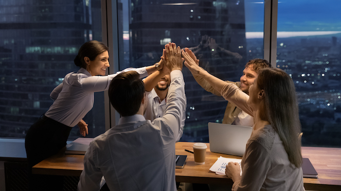 A group of workers staying late at night with the boss, who cares about their mental wellness, to finish a project and have a solution - demonstrating good mental wellness at work.