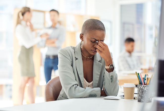 Female employee who is stressed out about her work, and it's affecting her mental wellness at work.