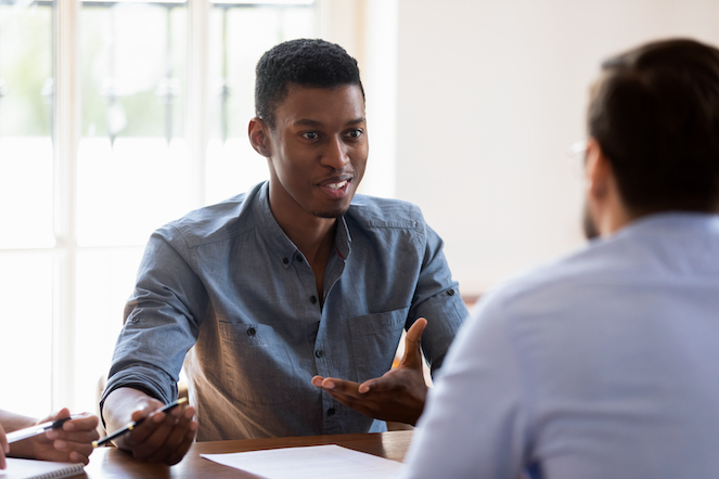 African American man communicating and engaging with his support person at work.