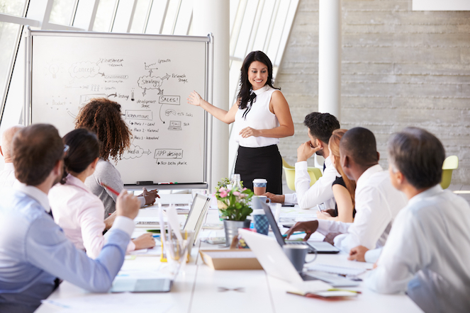 Hispanic woman communicating and engaging with her team and demonstrated measured progress. 