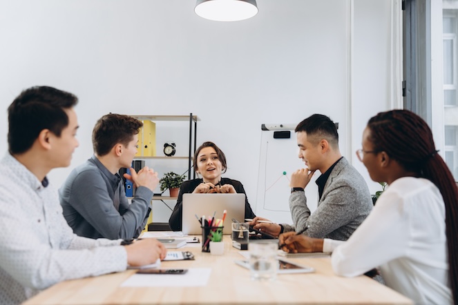 Boss engaging with her diverse business team in an office