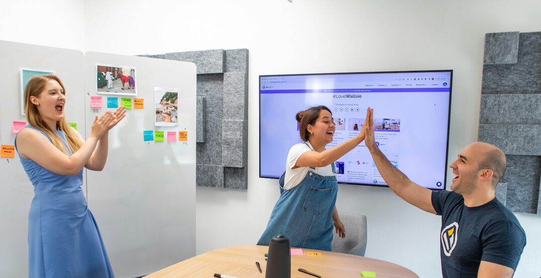 Teammates high-fiving at work