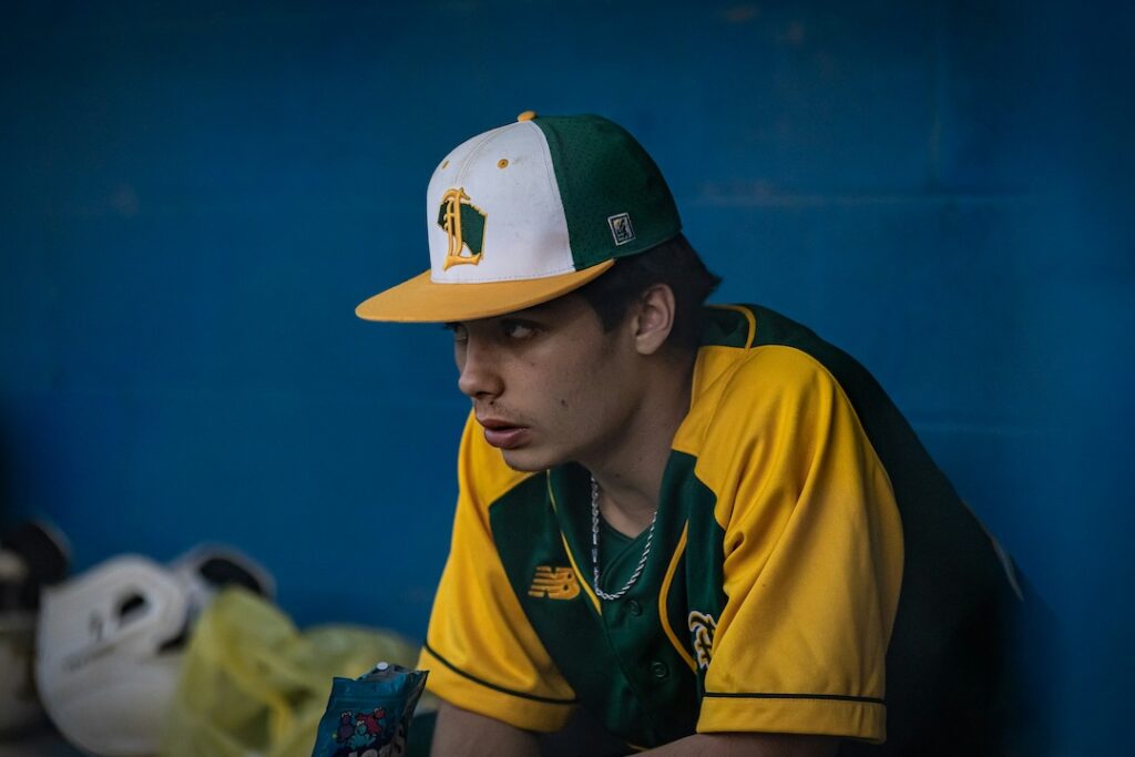Young man sitting on the bench looking intense, focused, and ready.