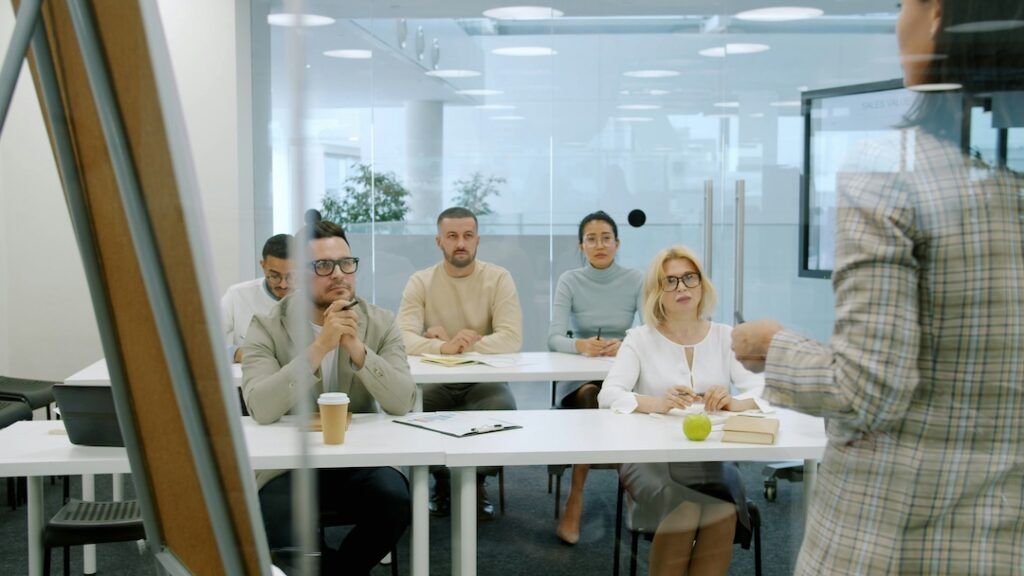 A small group of people sitting attentive and listening to a speaker in a training session.