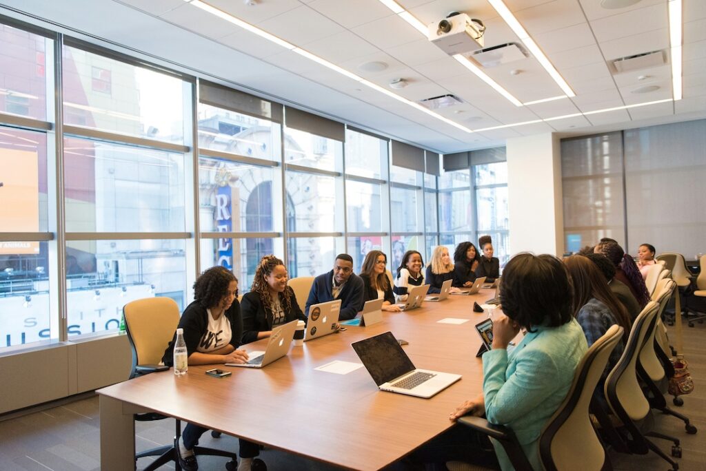 A meeting at a conference table with every seat filled and everyone engaged.