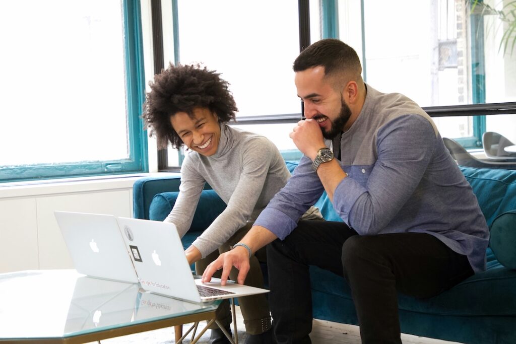 Two employees working together in an office and having fun.
